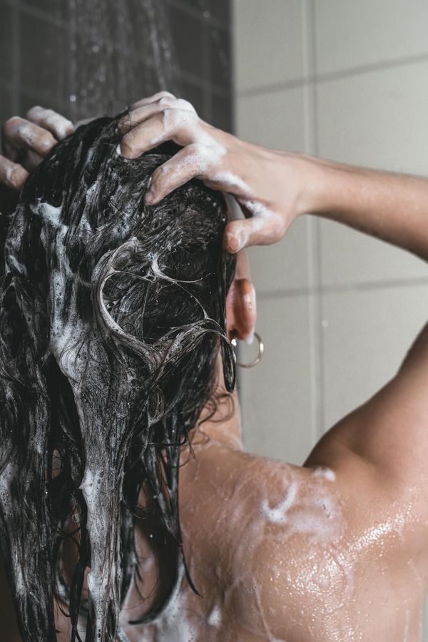 woman washing hair from behind seen from shoulders up