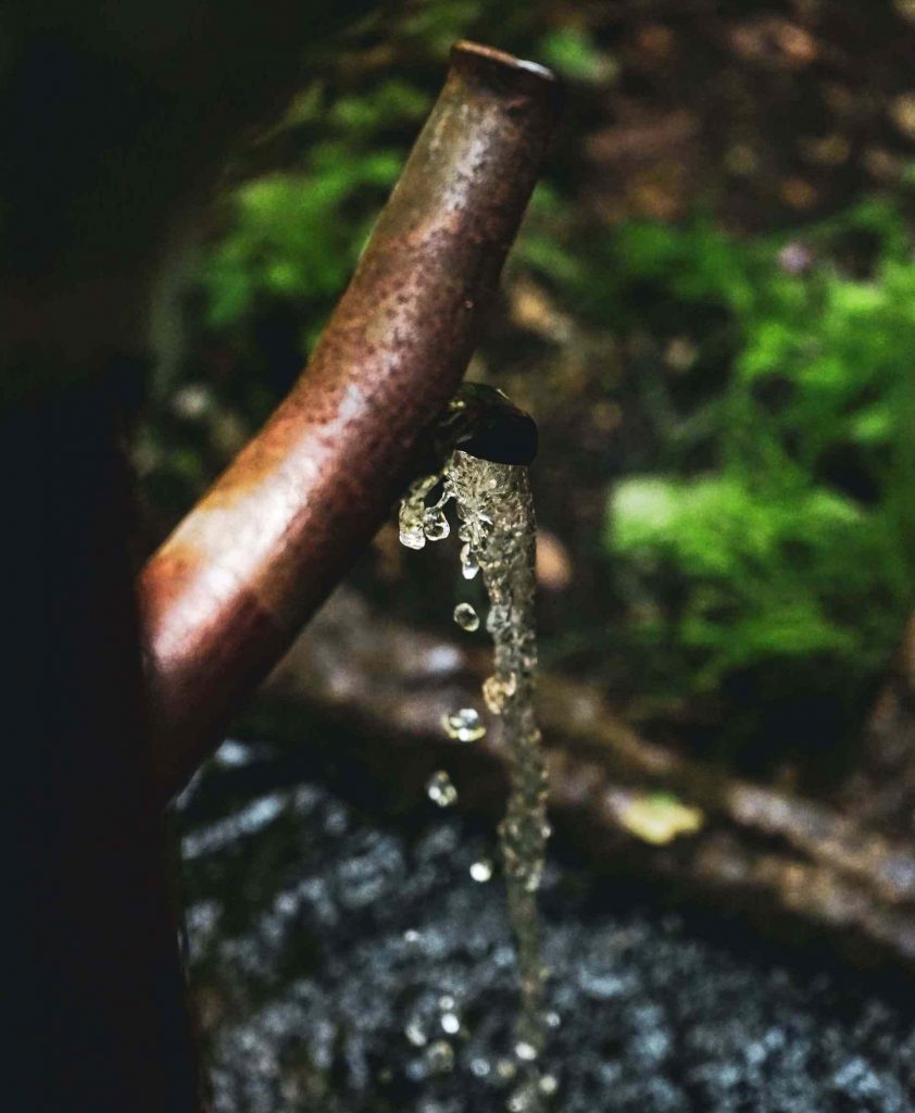 water flowing from rusty pipe outdoors